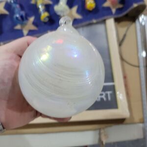 A band of swirled‎ white glass encircles these colorful balls like dancing...